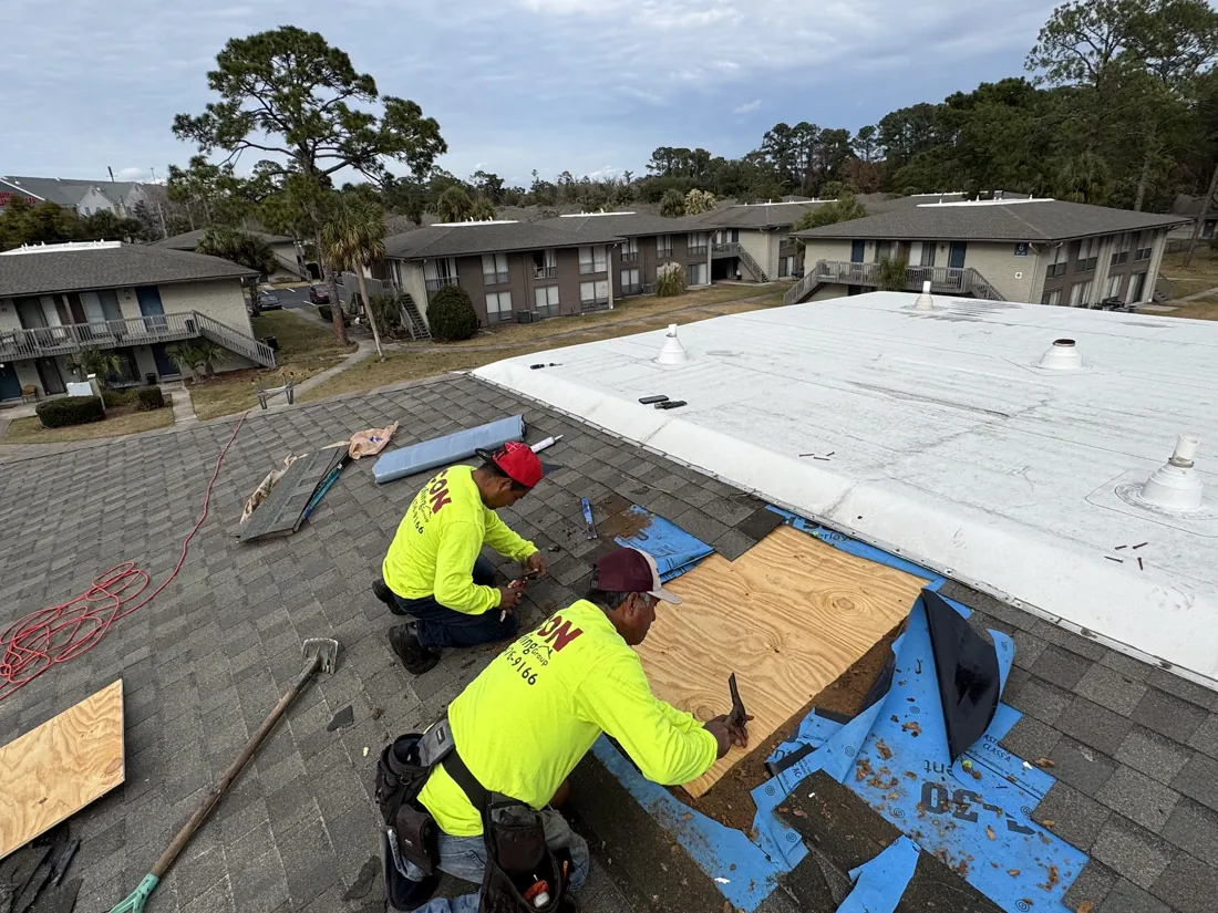 Icon Roofing crew installing a flat low-slope roof section next to a shingle roof
