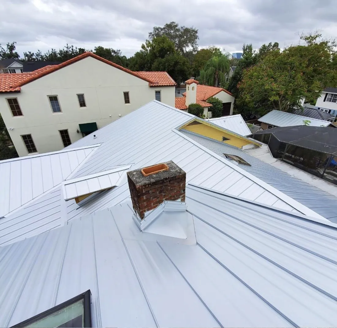 Silver standing seam metal roof with brick chimney flashing, Central Florida