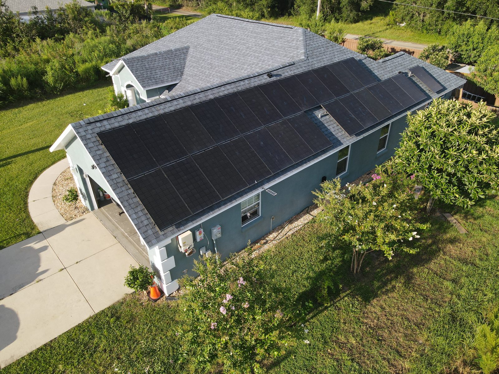 Aerial drone view of a completed residential solar panel installation on an asphalt shingle roof in Orlando, FL